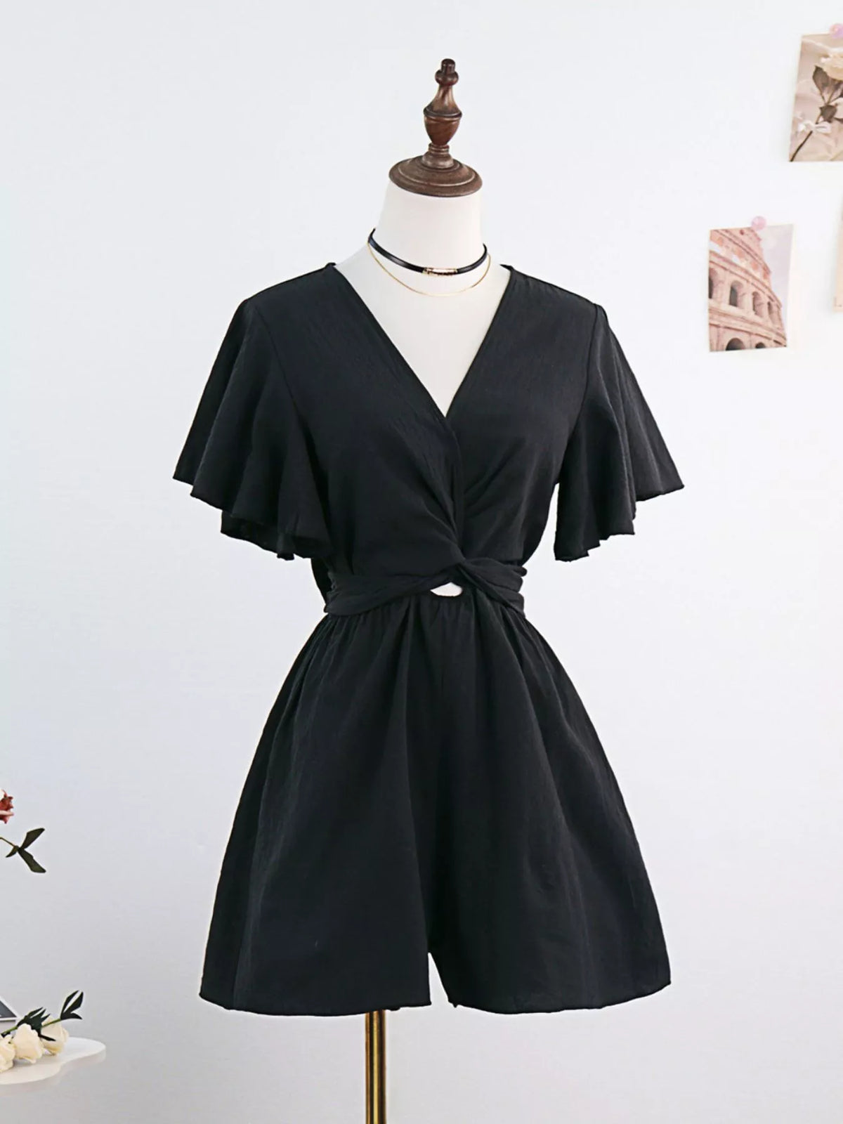 Black flutter-sleeve tie-waist romper on mannequin, front