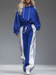 Royal blue drawstring hoodie and blue-and-white wide-leg pants set, full-length walking view.