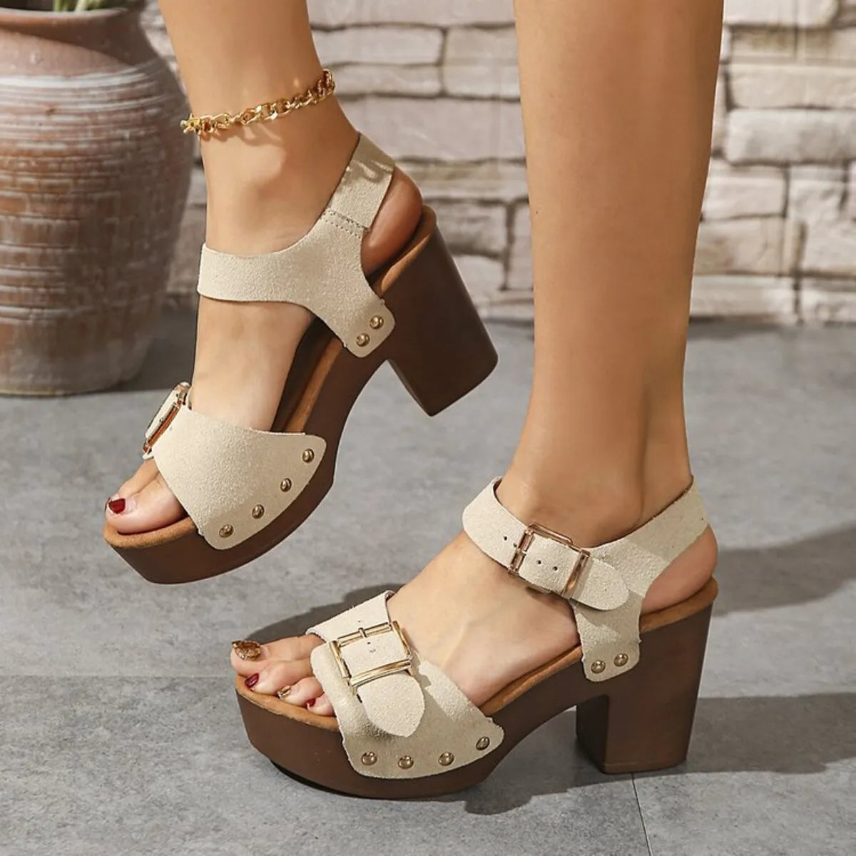 Cream open-toe platform sandals with ankle buckles and studded front straps, front angled view