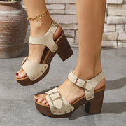 Cream open-toe platform sandals with ankle buckles and studded front straps, front angled view