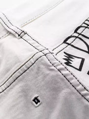 Close-up of black printed detail and stitching on white jeans