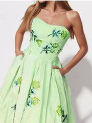 Close view of the light green strapless dress bodice with embroidered floral accents.