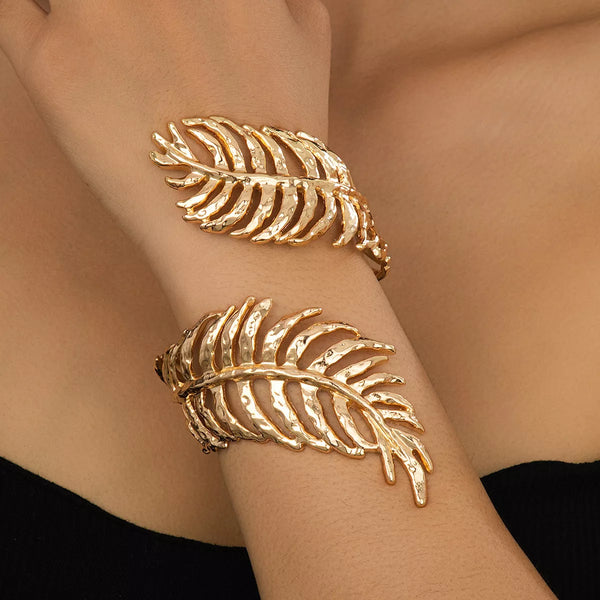 Gold-tone open leaf cuff bracelet worn on wrist