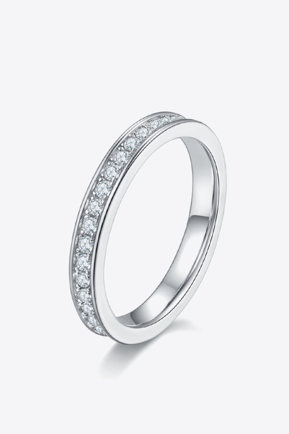 Angled view of a slim stone-set half-eternity ring on a white background.