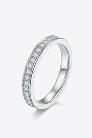Angled view of a slim stone-set half-eternity ring on a white background.
