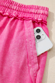 Close-up of side pocket on pink shorts with phone tucked inside