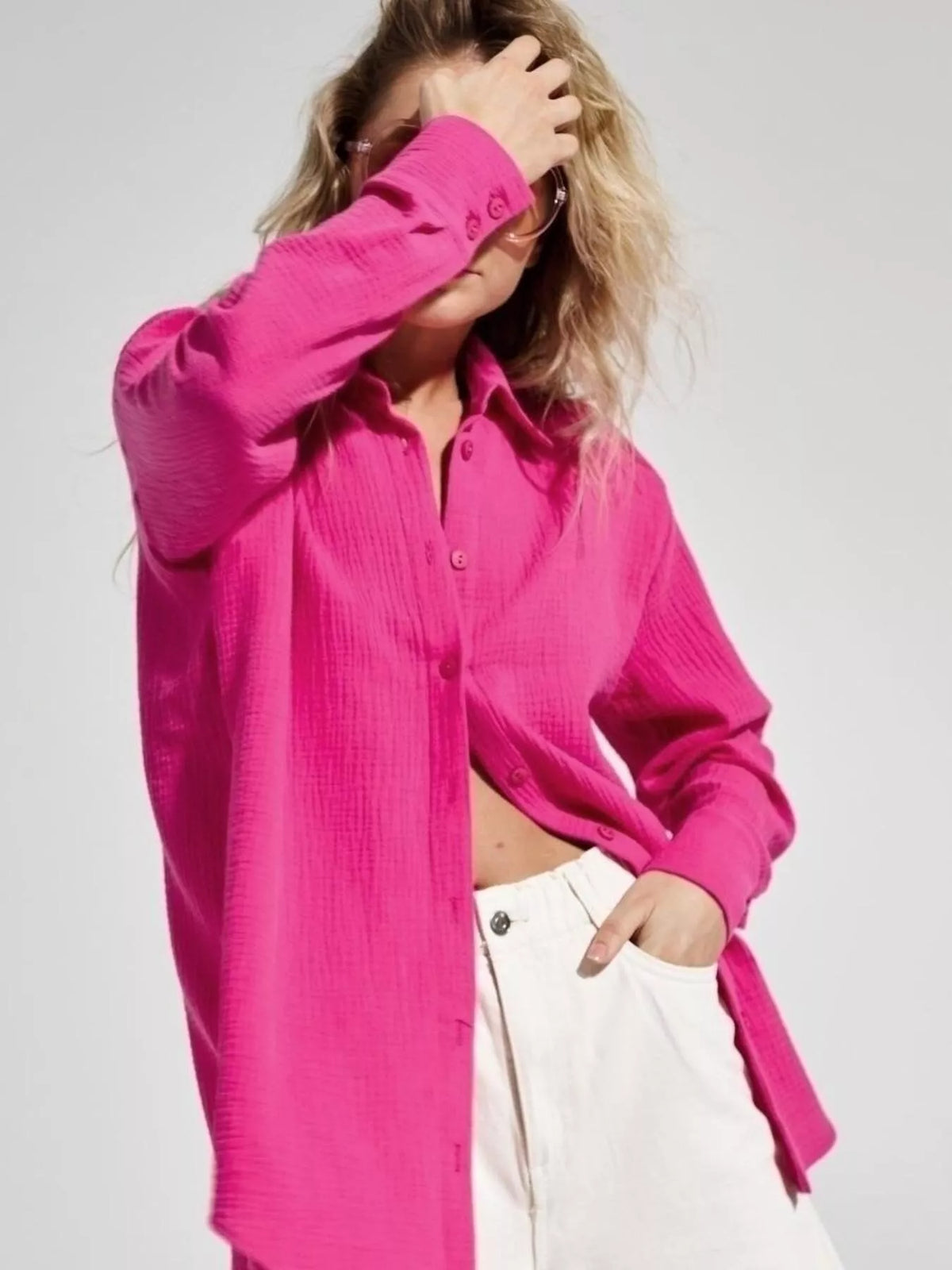 Model wearing a bright pink gauze button-down shirt.