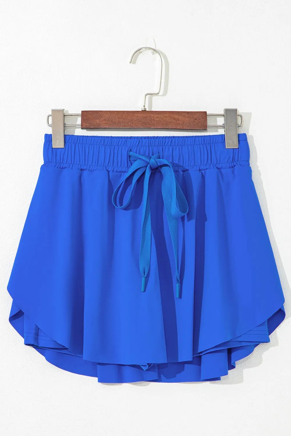 Blue active skort displayed on a hanger, showing the back and layered hem