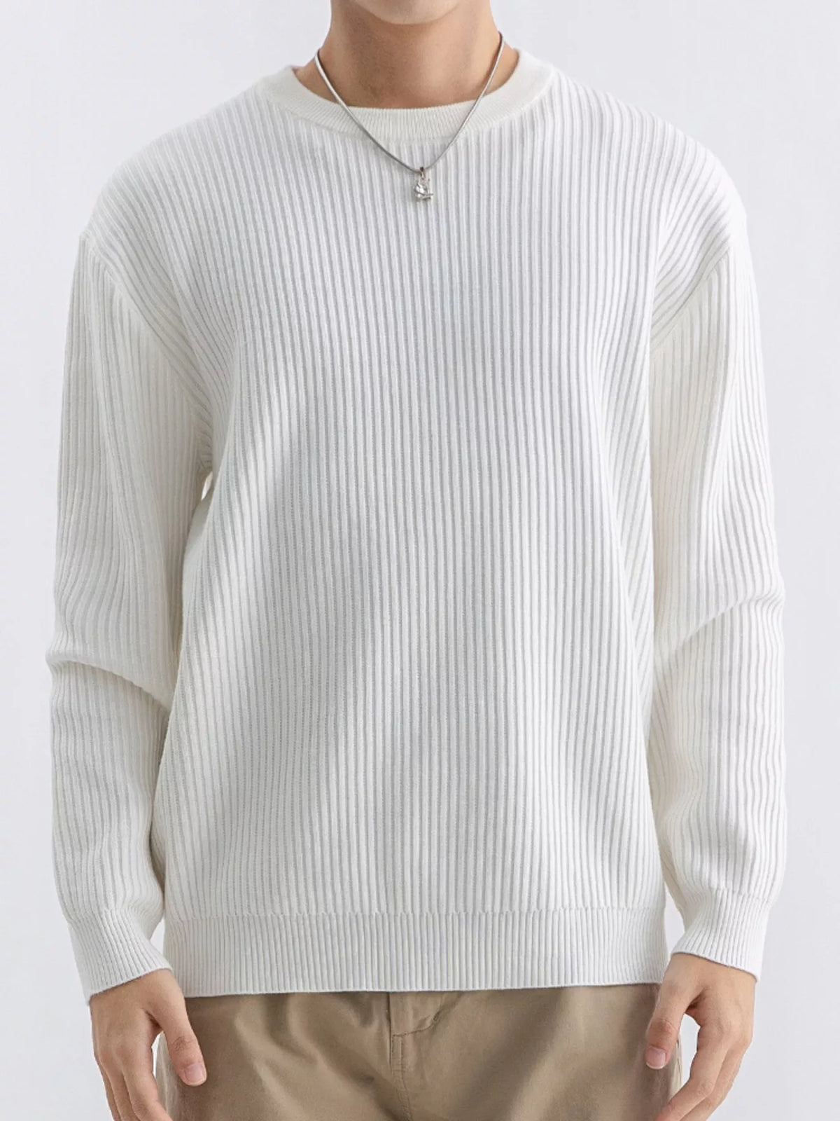 Front view of ivory ribbed crew-neck sweater showing long sleeves and ribbed hem