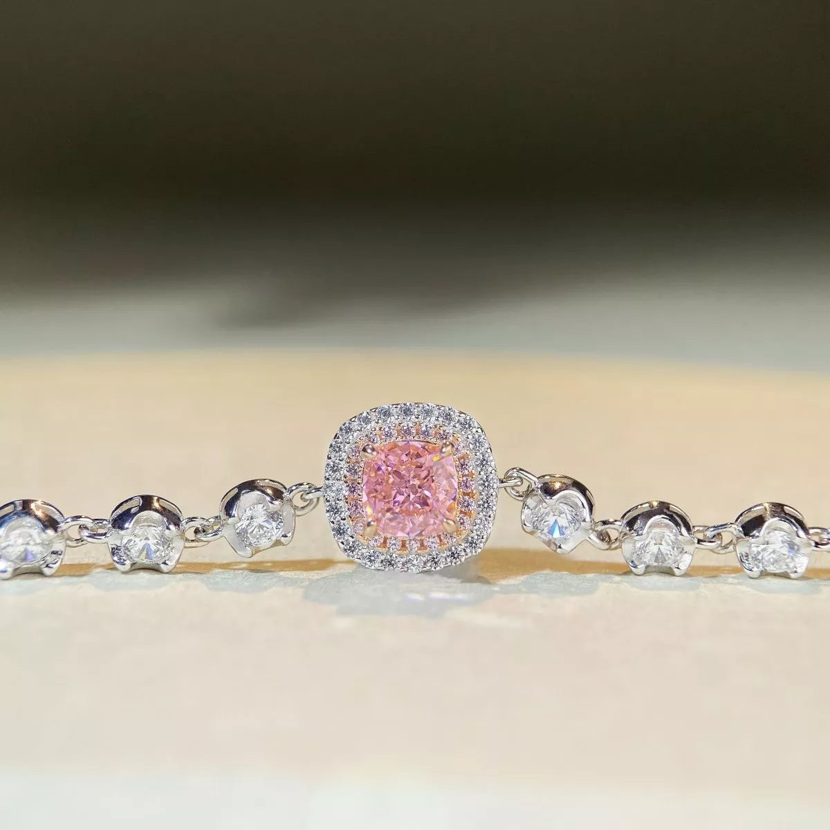 Front view of a pink square center stone framed by clear stones and round side accents