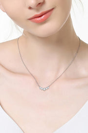 Model wearing a delicate curved moissanite pendant necklace
