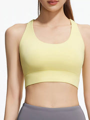 Front view of pale yellow scoop-neck active bra with wide underband and grey leggings