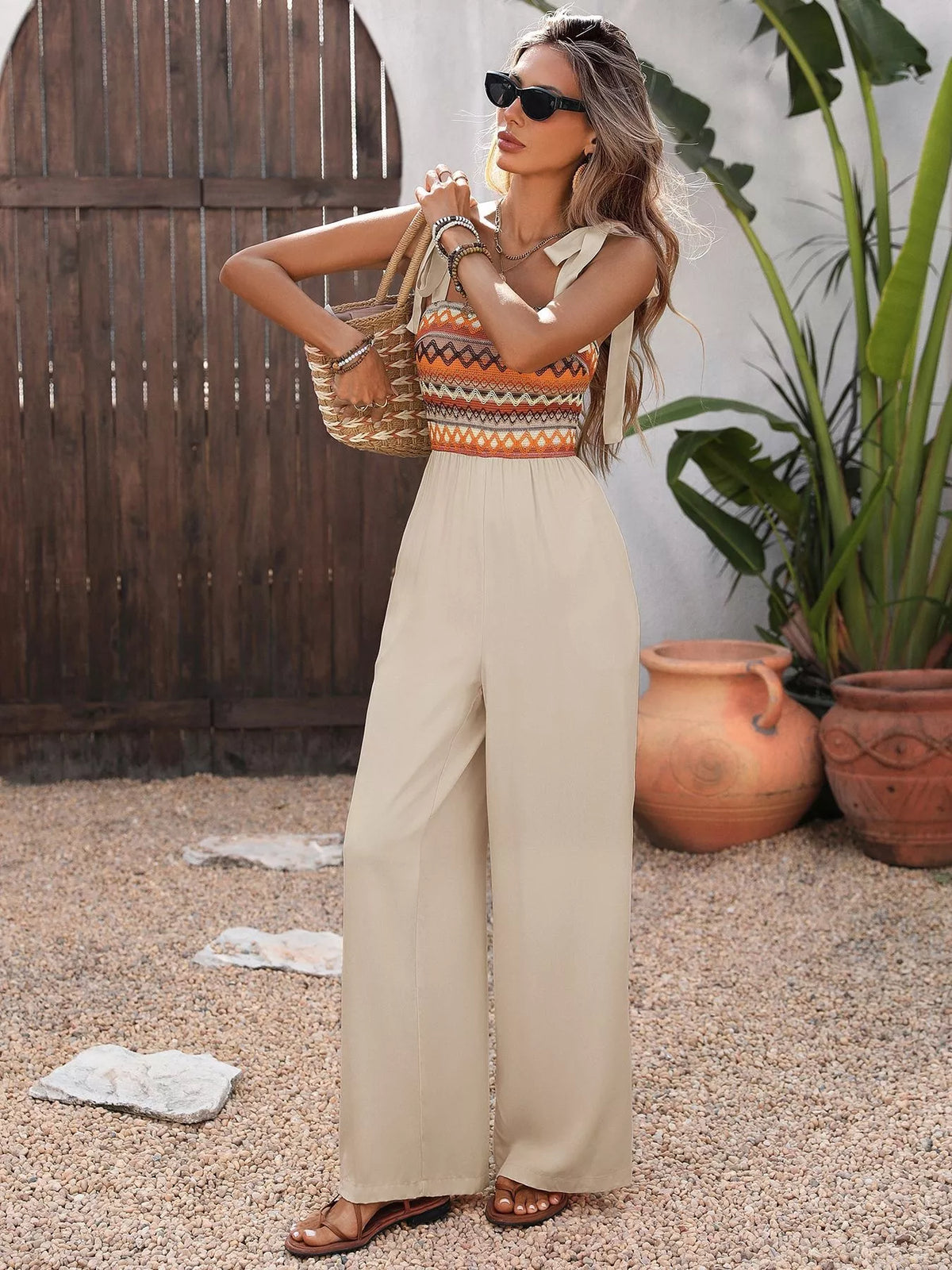 Apricot jumpsuit styled with woven bag