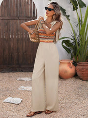 Apricot jumpsuit styled with woven bag