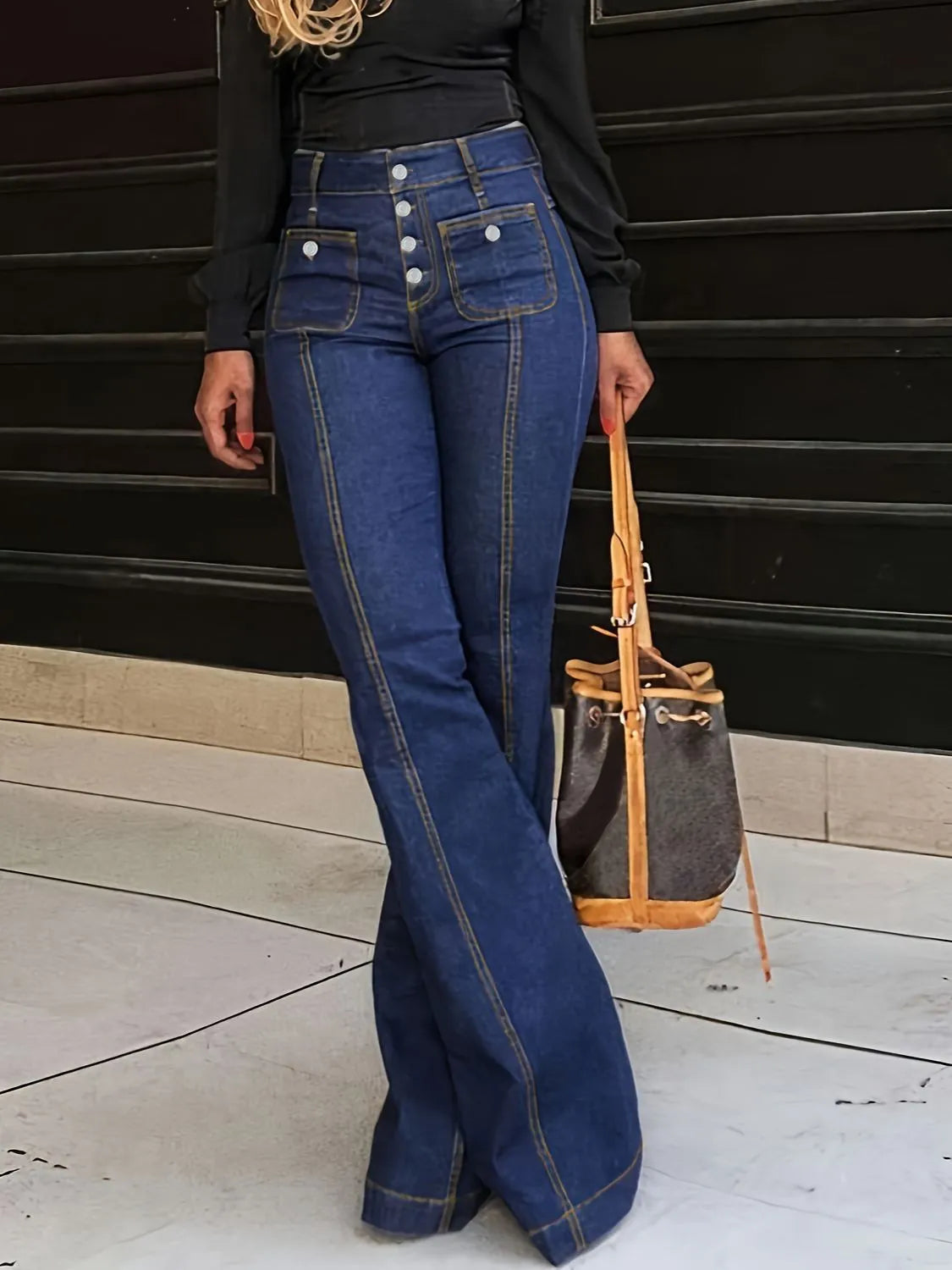 Dark blue flare jeans worn with black top, front view