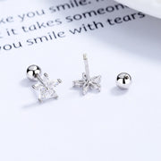Backs of silver-tone flower stud earrings showing posts and ball backs