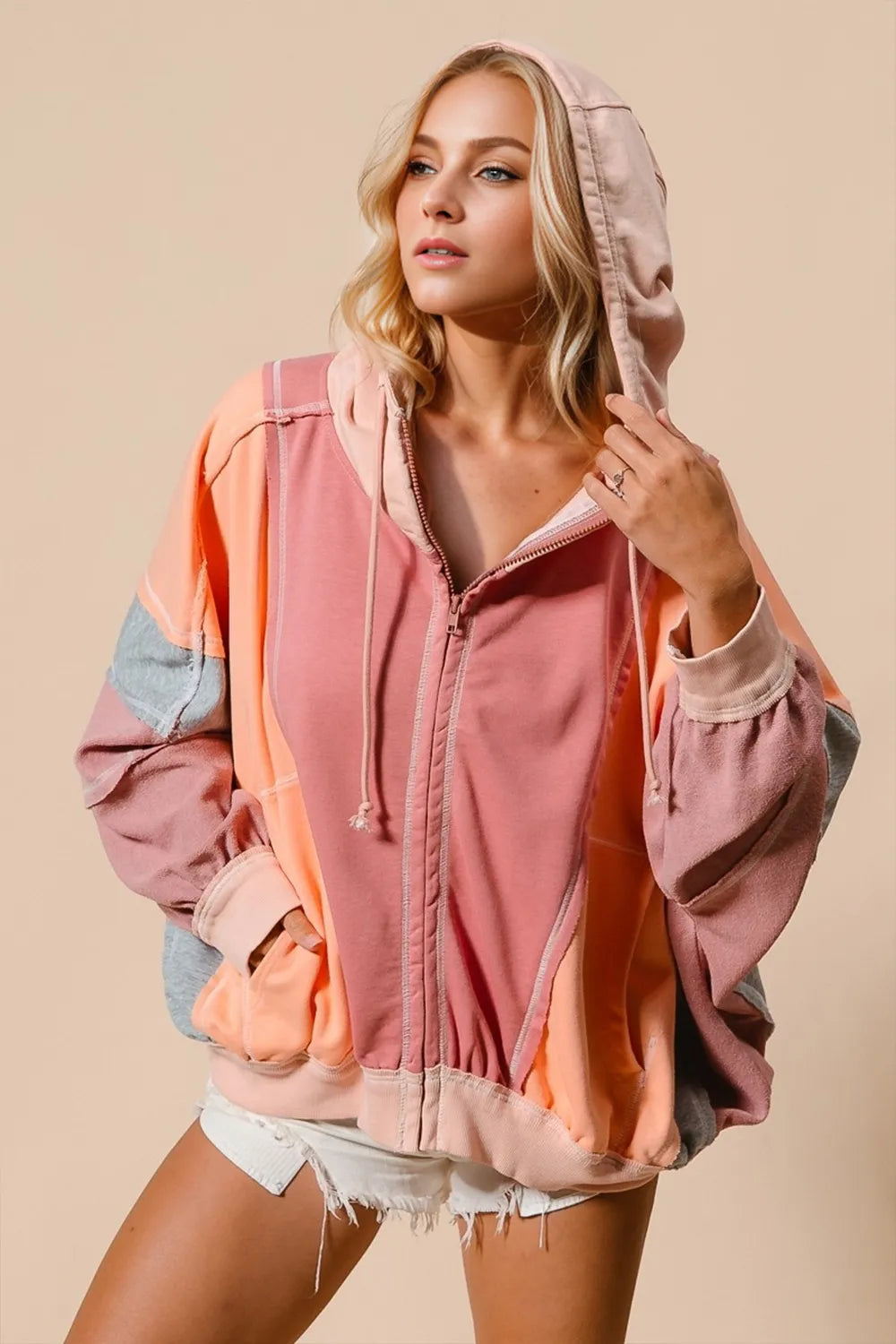 Color-block hoodie in mint, pink, and orange with a front zipper and hood.