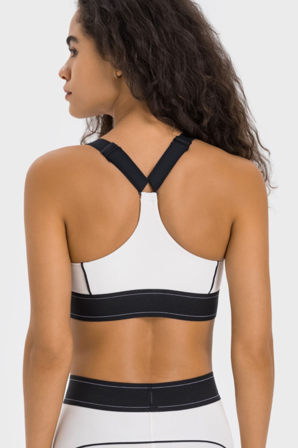 Back view of white sports bra with black racerback straps and hem