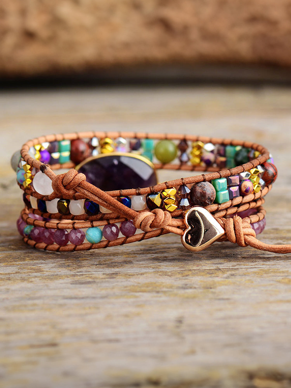 Close detail of the bracelet’s purple centerpiece, beads, and dangling heart charm.