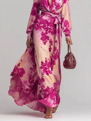 Lower view of the flowing pink floral maxi dress showing the waist tie and moving hem.