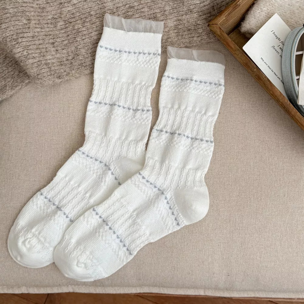 Pair of white knit socks with gray decorative stripes