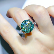 Green-blue ring worn on hand, showing silver setting