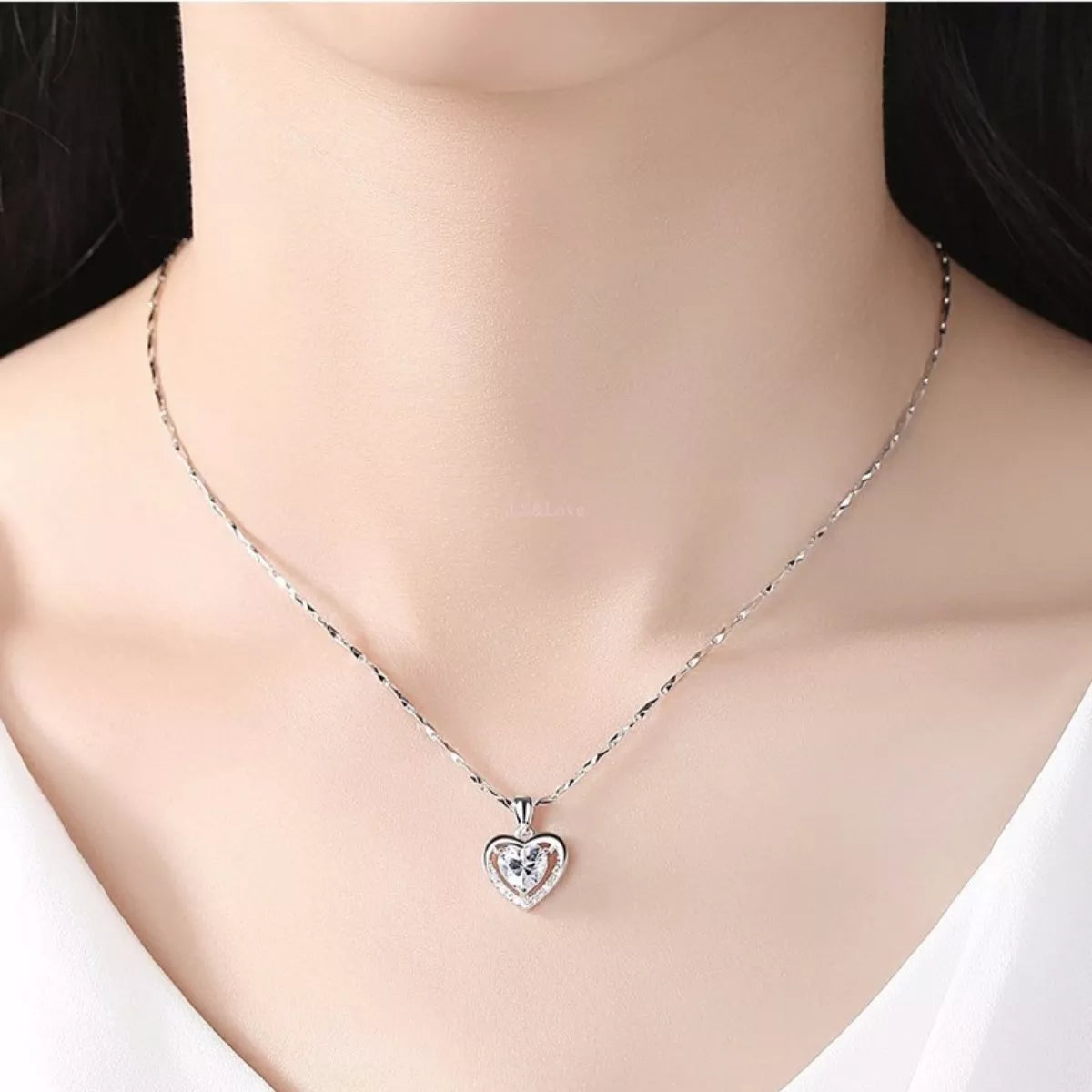 Model wearing a small heart pendant necklace
