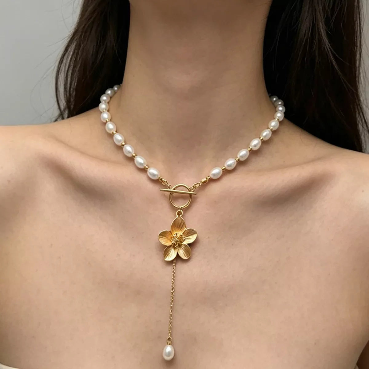 Front view of pearl choker with gold toggle clasp, flower pendant and pearl drop