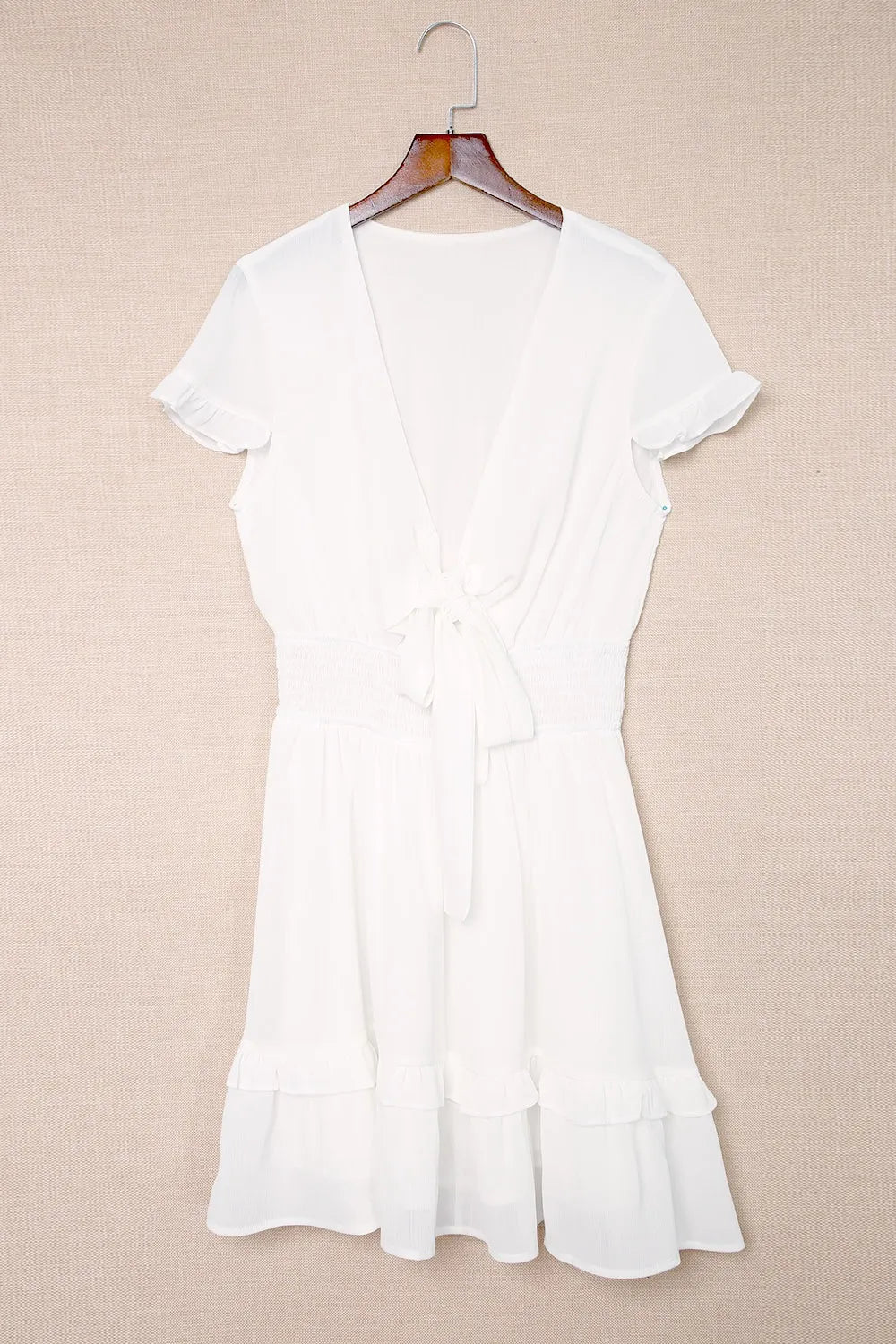 White dress displayed on hanger, front