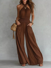 Front view of brown halter-neck wide-leg jumpsuit with smocked waist and pockets