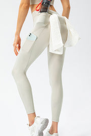 Rear view of ivory pocket leggings with a phone and towel tucked at the hip