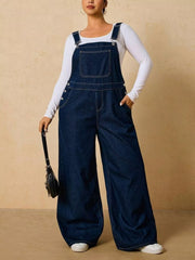 Dark blue wide-leg overalls shown with one hand in a hip pocket and a black bag.