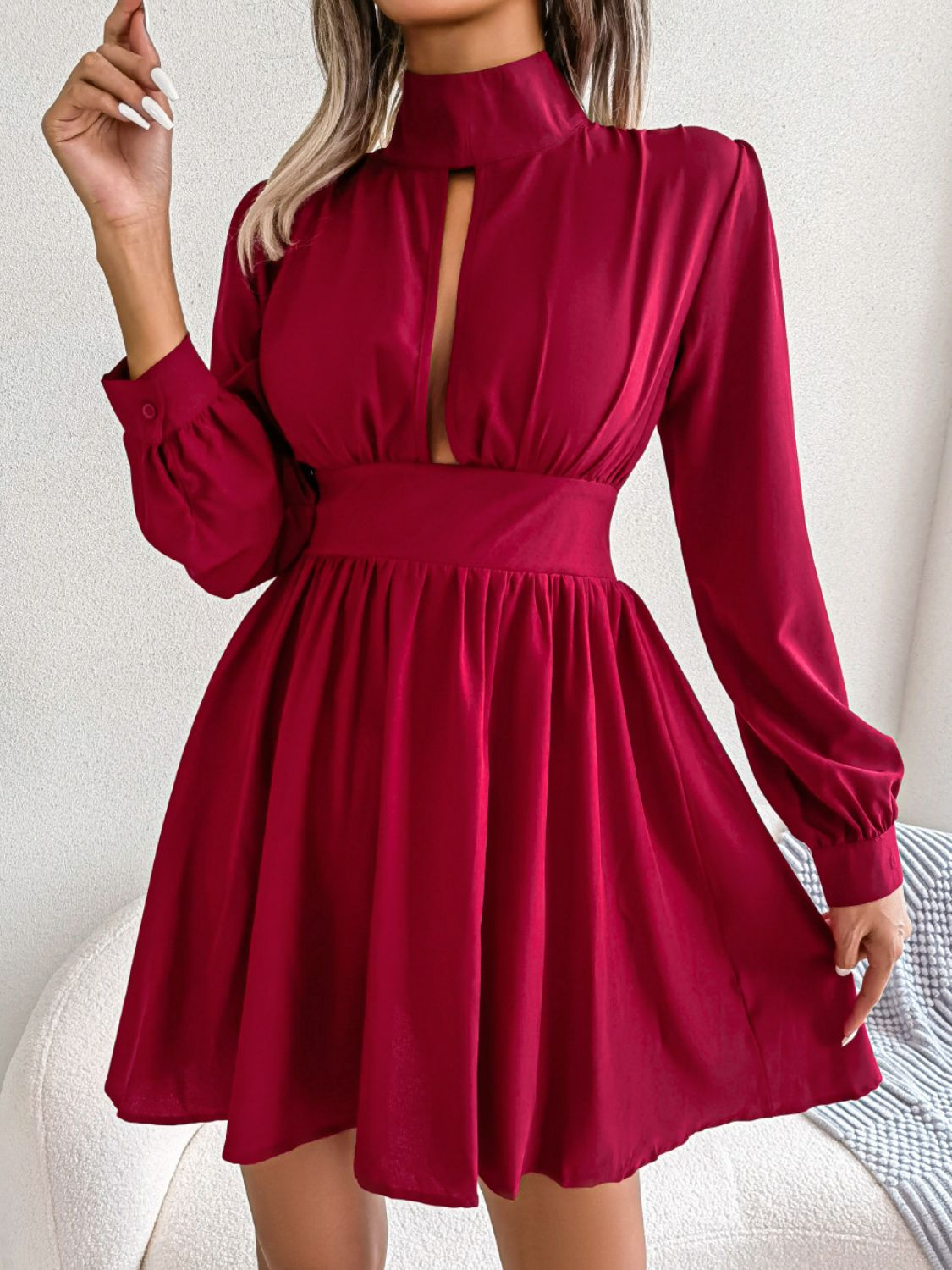 Model in a burgundy cutout turtleneck A-line mini dress, front view