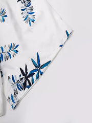 Close-up of a hem on the white shorts with blue leaf print