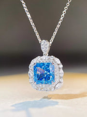Angled close-up of blue rectangular pendant with clear stone surround and teardrop-shaped bail