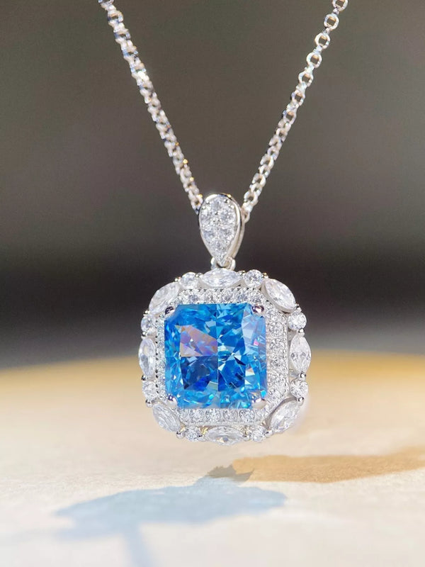 Angled close-up of blue rectangular pendant with clear stone surround and teardrop-shaped bail