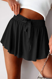 Blue drawstring skort worn at the waist with flared skirt overlay