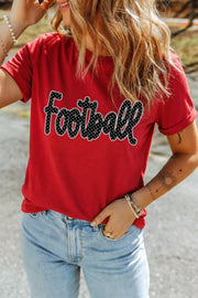 Front view of red Football lettering T-shirt with one hand in jeans pocket