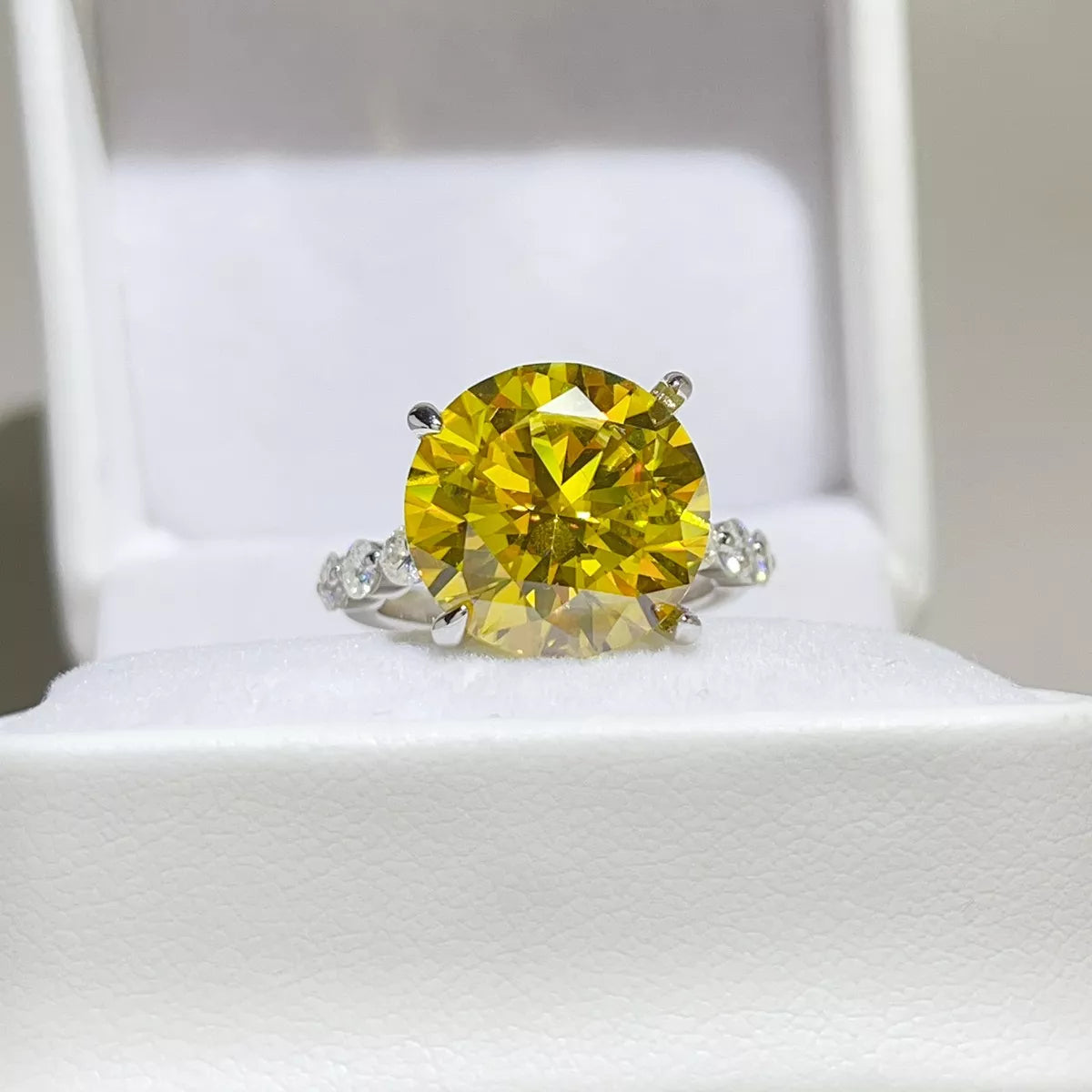 Yellow round-stone ring displayed in a white jewellery box