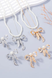White beaded necklaces and matching bow earrings in silver-tone and gold-tone finishes