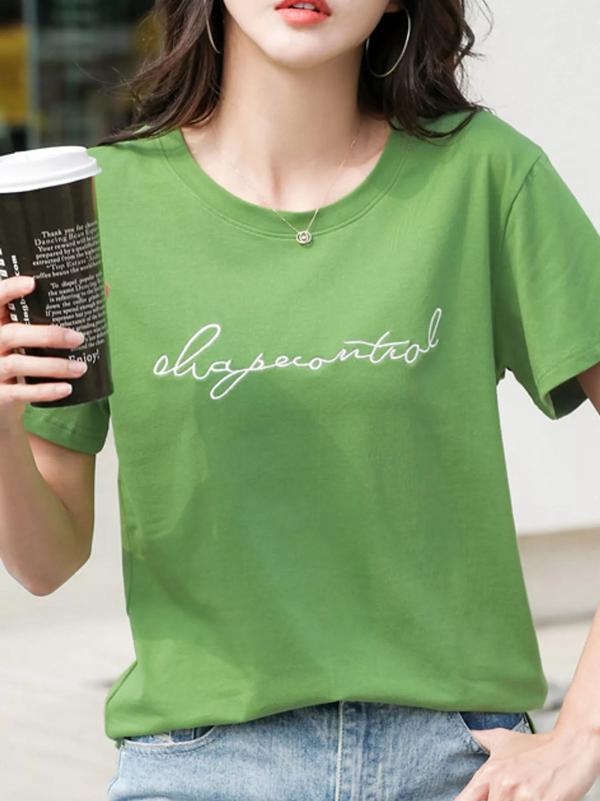 Model wearing a green crew-neck T-shirt with embroidered script lettering