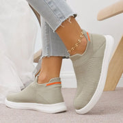Rear side view of beige knit slip-ons showing orange heel stripes