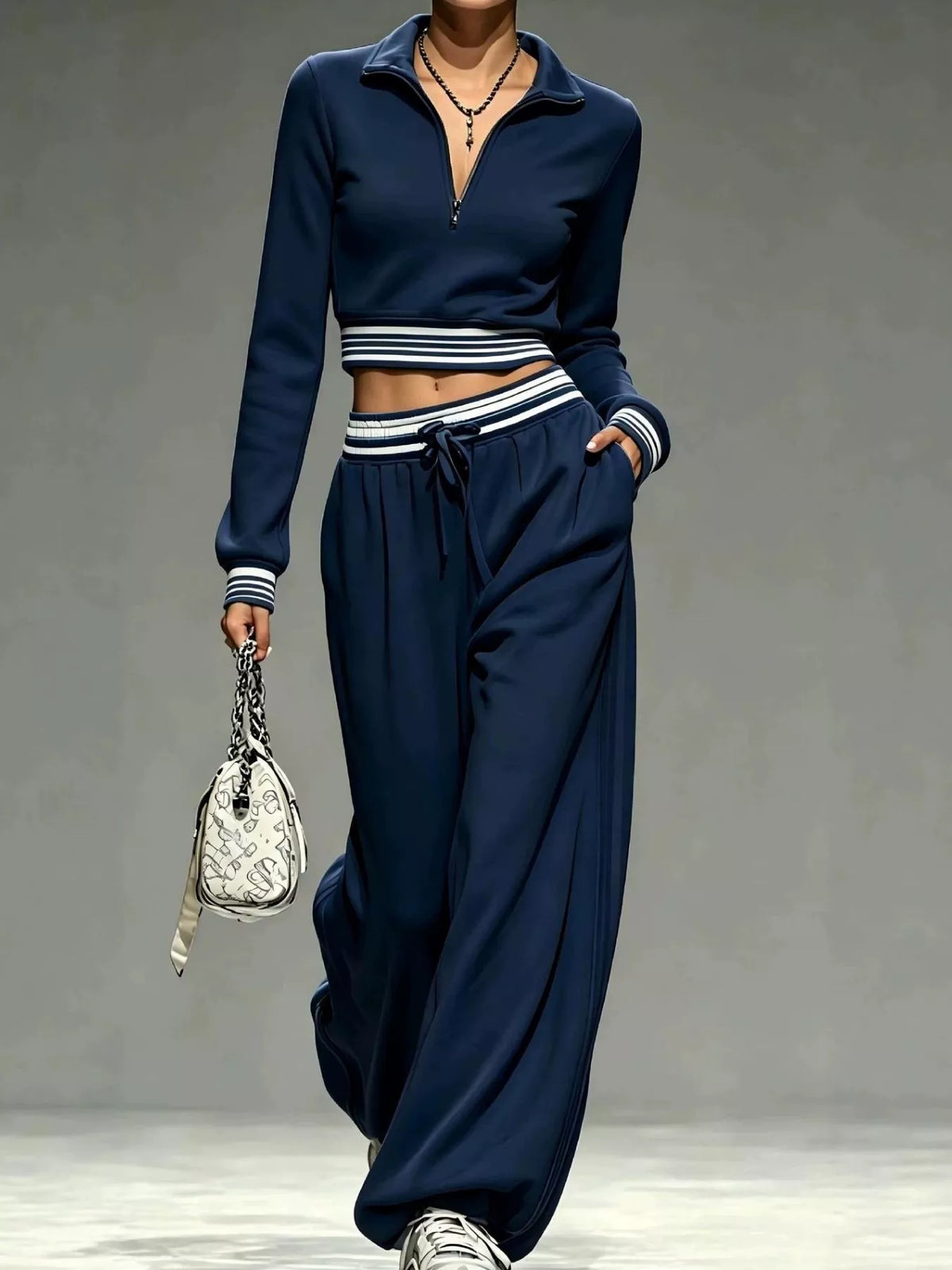 Closer view of navy cropped half-zip top with striped trim and drawstring pants
