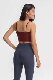 Back view of a model wearing a burgundy cropped cami with navy leggings.