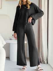 Black wide-leg lounge pants with drawstring waist shown in a cropped view