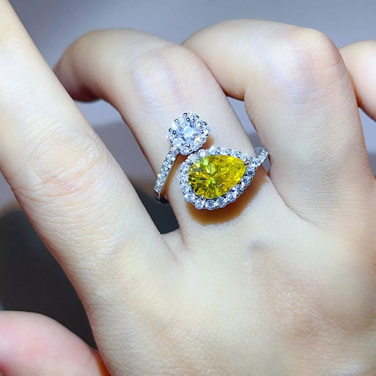 Yellow pear-shaped centre stone with pavé halo and opposing cluster, worn on hand