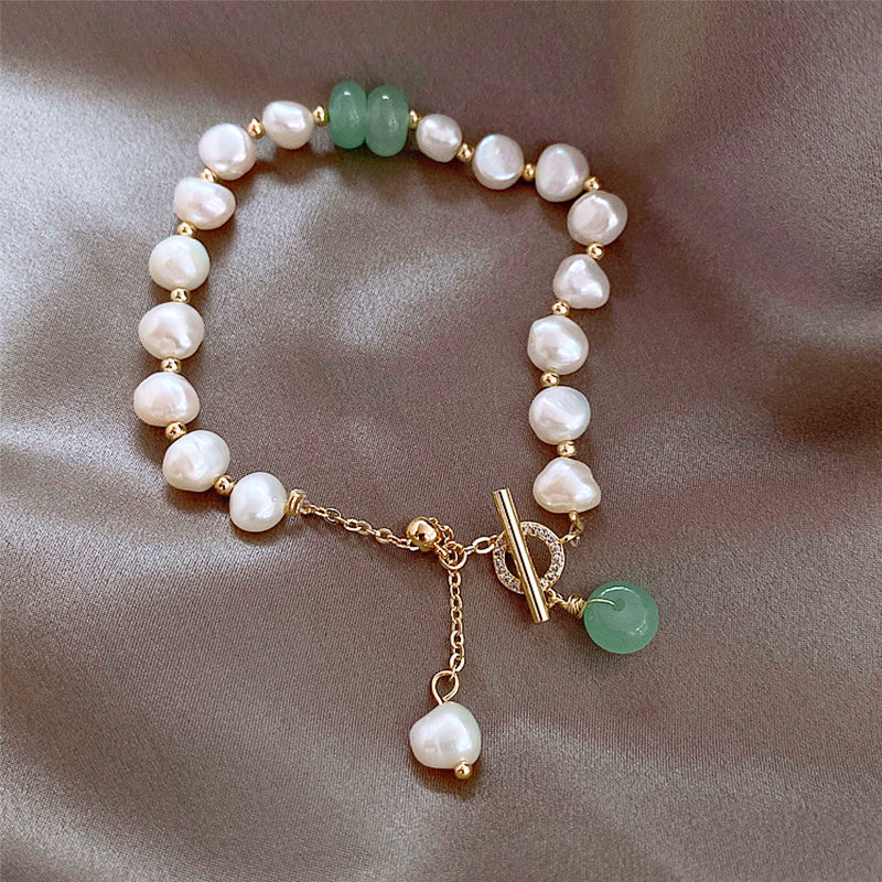 Pearl and green stone bracelet worn around the wrist