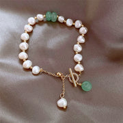 Pearl and green stone bracelet worn around the wrist