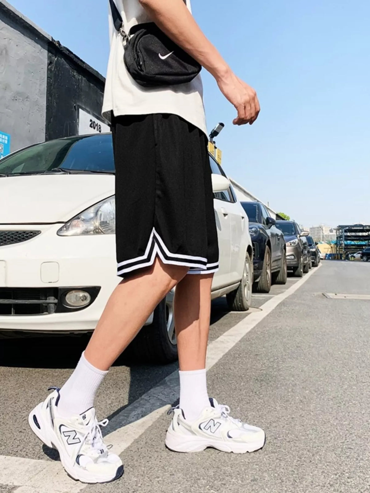 Model wearing black shorts showing side and hem trim