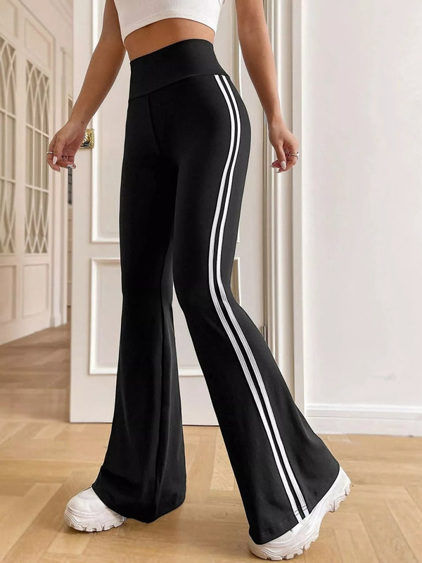 Black flare active pants with twin white side stripes, three-quarter view